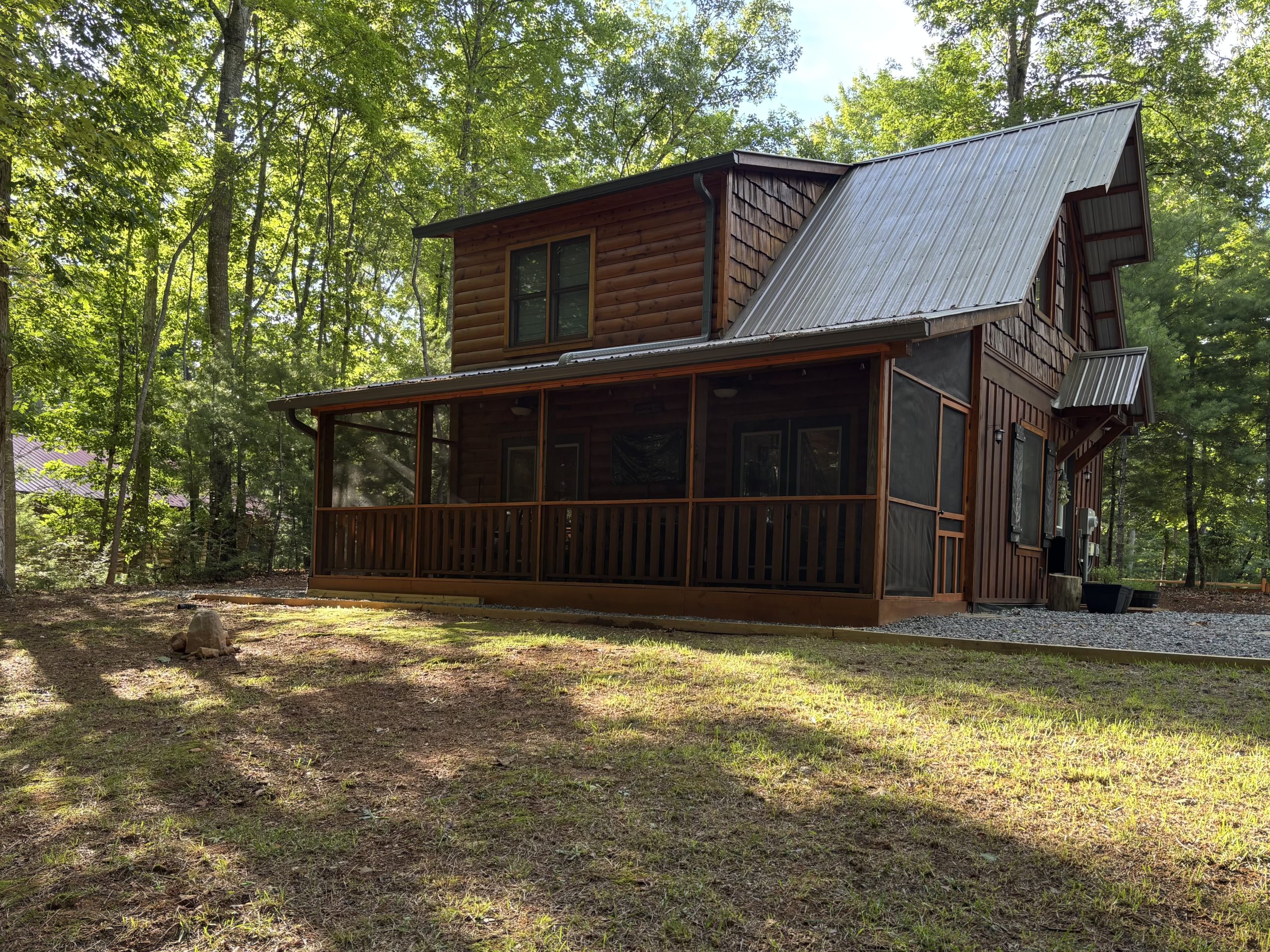 Wooded side and screened porch exterior of The Cozy Nook