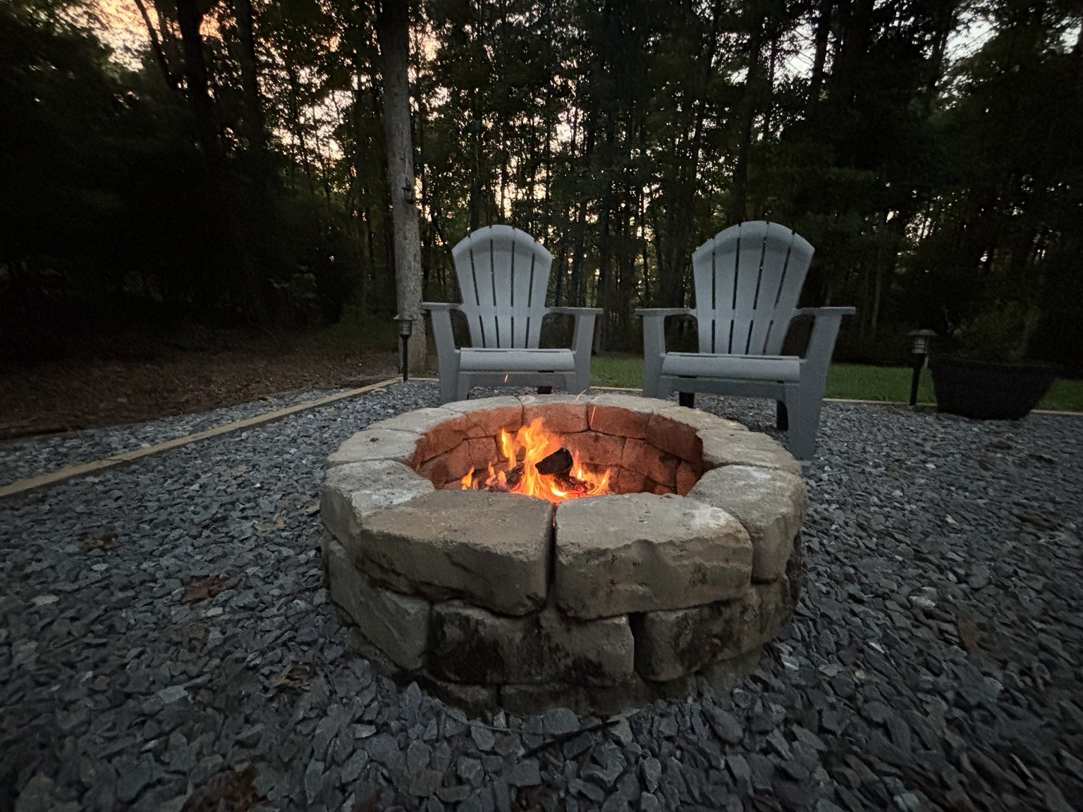 Wood fire glowing in the private stone fire pit at The Cozy Nook