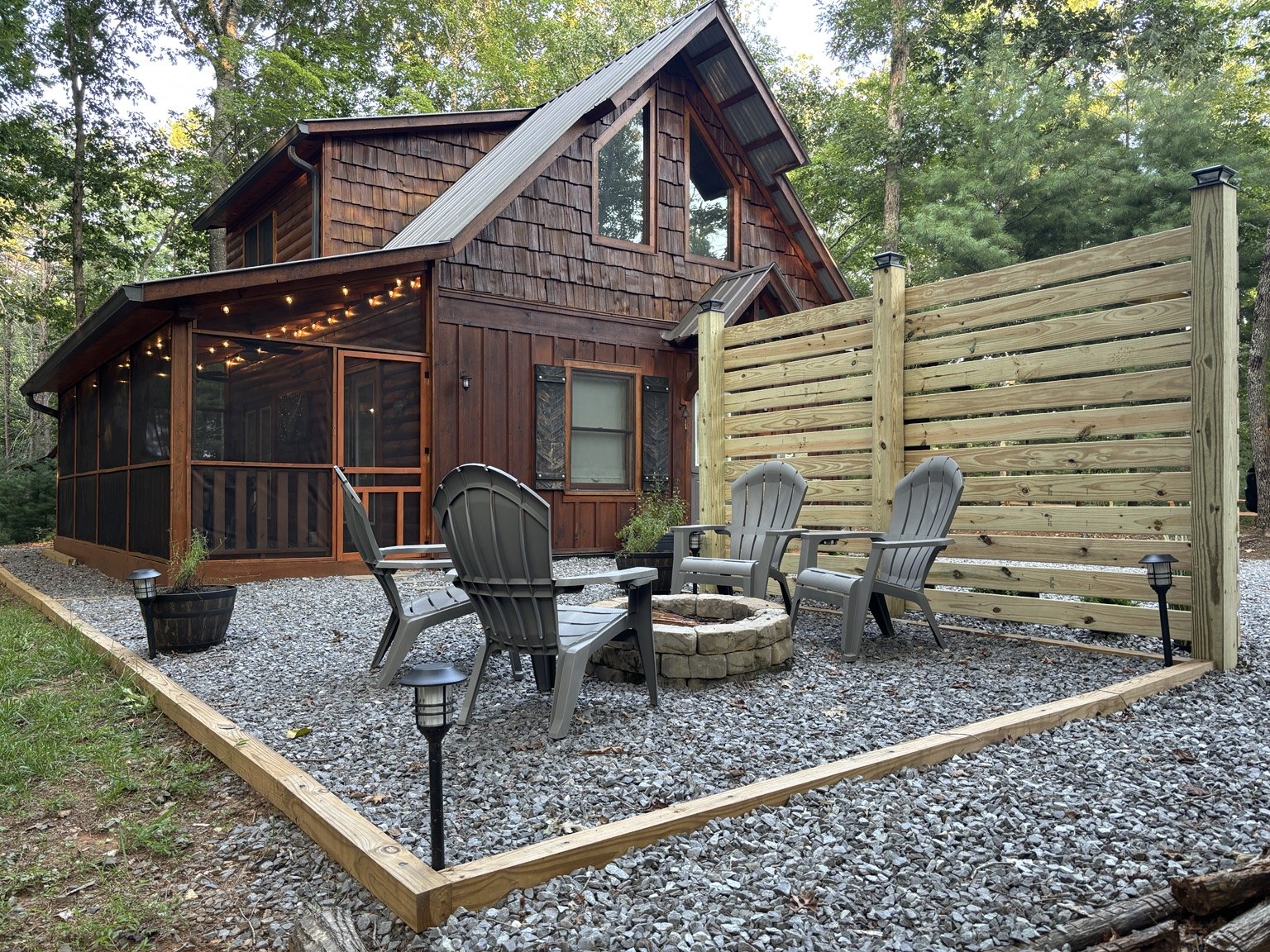 Private fire pit with four Adirondack chairs beside The Cozy Nook cabin