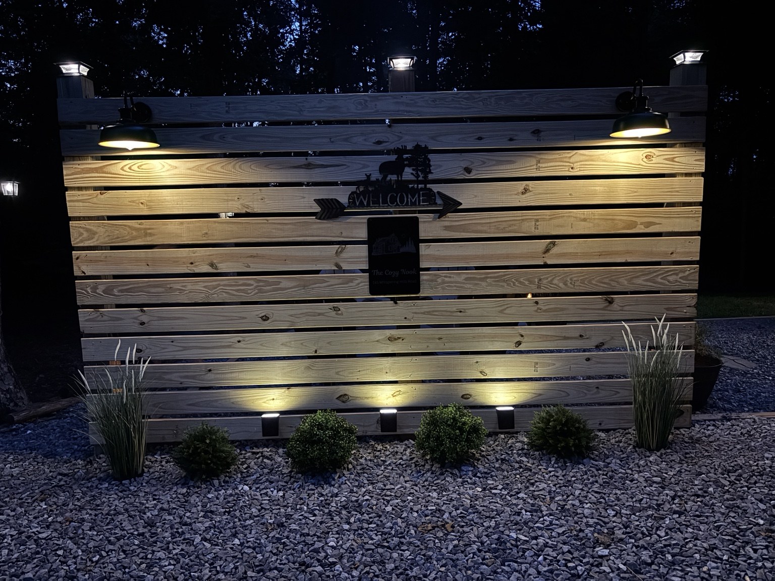 Warmly illuminated privacy screen at The Cozy Nook outdoor fire pit retreat